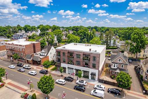 A street view of a town with cars parked on the side of the road.