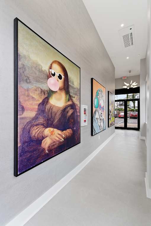 A wall with a painting of a woman and other paintings.