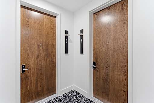 A hallway with two doors and a carpeted floor.