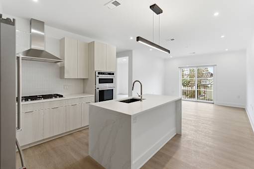 A modern kitchen with a large island and stainless steel appliances.