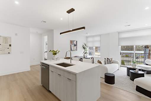 A modern kitchen with a large island and a dining area with a view.