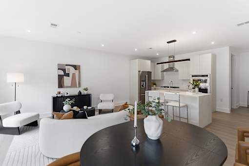 A modern living room with a black table and white furniture.