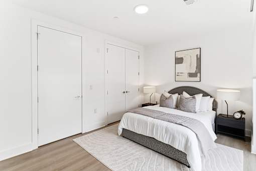 A bedroom with a bed, nightstands, and a framed picture on the wall.