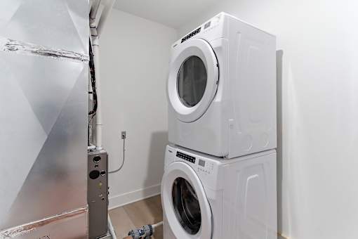 A washing machine and dryer stacked on top of each other in a laundry room.