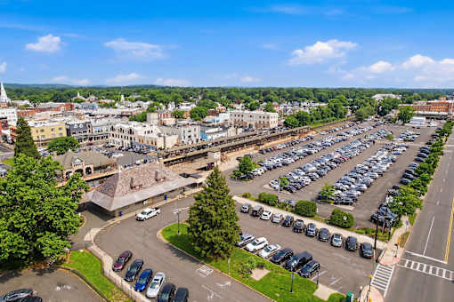 A parking lot with cars and a town in the background.
