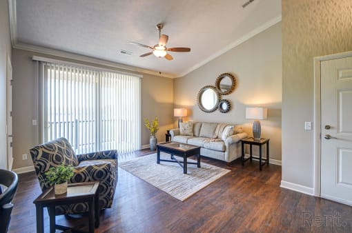 a living room with a ceiling fan and hardwood flooring