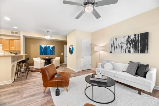 a living room with a white couch and a ceiling fan