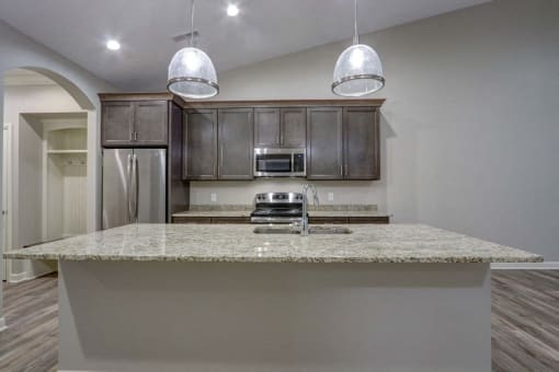 a kitchen with granite countertops and dark wood cabinets