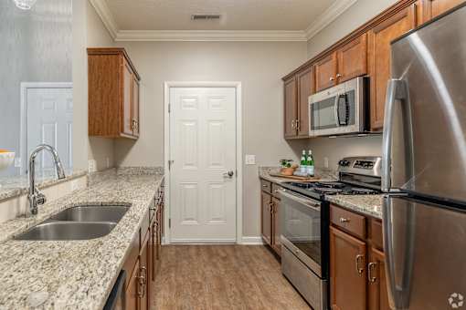 A kitchen with a sink, stove, and refrigerator.