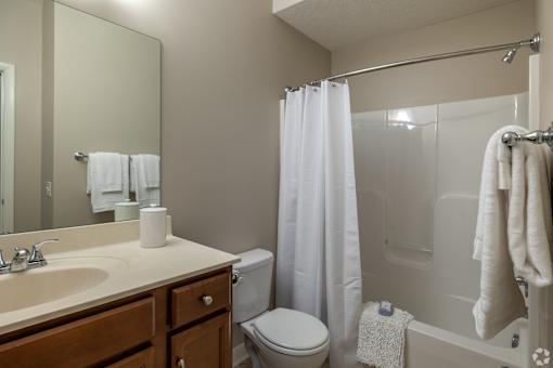 A bathroom with a toilet, sink, and shower.