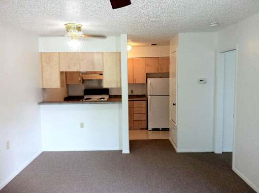 A kitchen with a refrigerator, microwave, and oven.