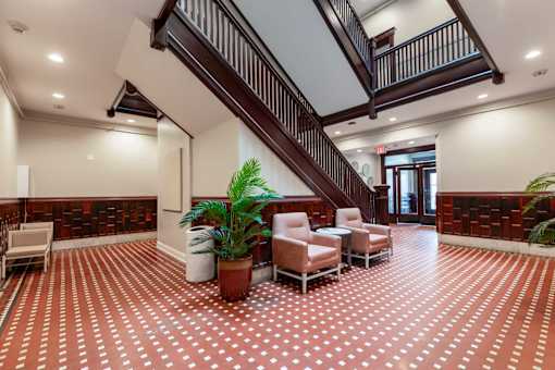 A living room with a staircase and a plant.