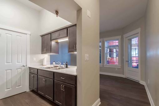 A kitchen with dark brown cabinets and a white countertop.