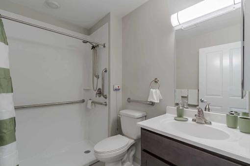 A white toilet is in a bathroom with a white sink.