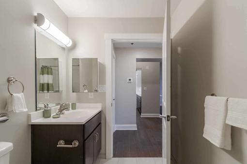 A bathroom with a white sink and a mirror above it.