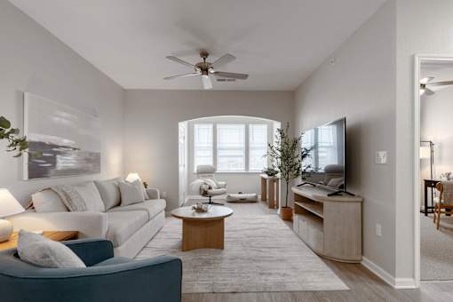 A living room with a white couch, a wooden coffee table, and a flat screen TV at Sunday Village