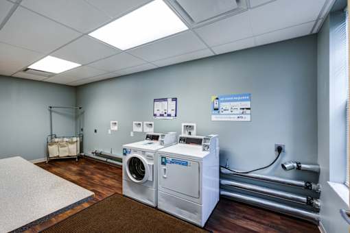 A room with a washing machine and a dryer.