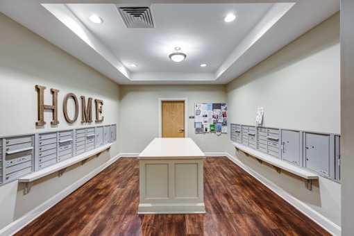 A room with a wooden floor and a large wooden HOME sign on the wall.
