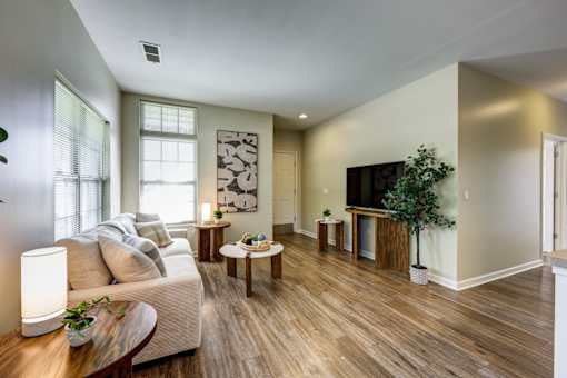 A living room with a white couch and wooden floors.