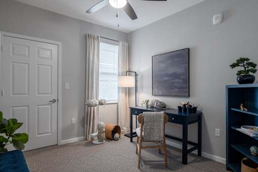 A room with a desk, chair, and a ceiling fan at Sunday Village, Texas