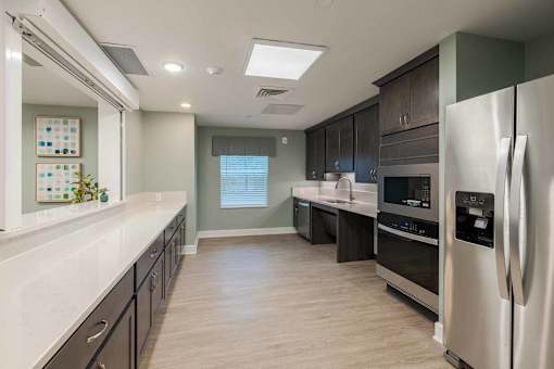 A modern kitchen with stainless steel appliances and wooden floors.