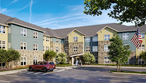 A red car is parked in front of a building with a flag on it. at Bretton Woods II Apartments, Columbus, OH, 43231