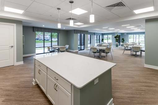 A large, empty room with a white counter and wooden floors.