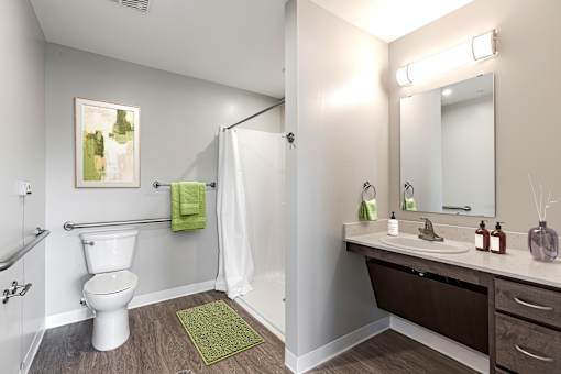 A bathroom with a toilet, sink, and mirror.