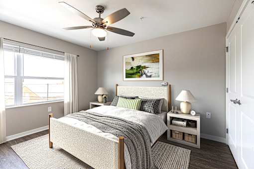 A bedroom with a bed, nightstands, and a ceiling fan.