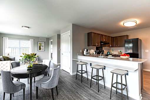 A modern kitchen with a dining table and chairs.