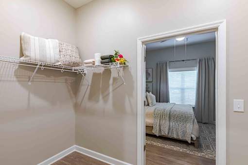 A bedroom with a bed and a closet with a shelf.