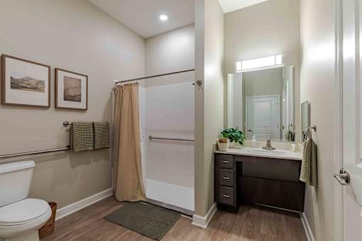 A bathroom with a toilet, sink, and shower.