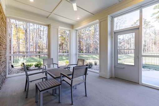 A sunroom with a table and chairs.