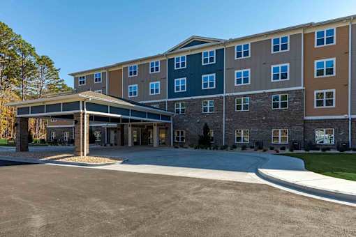 A large multi-story building with a parking lot in front.
