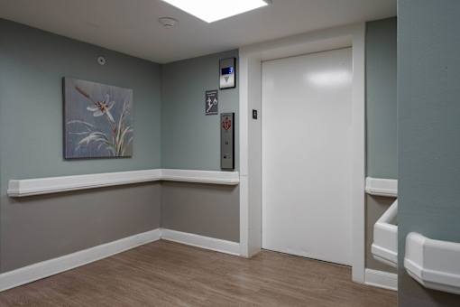 A long hallway with two elevators on the left side.