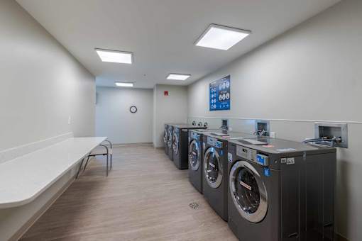 A laundromat with a row of washers and dryers.