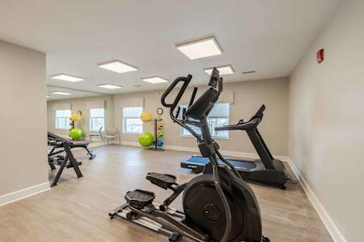 A spacious gym with a variety of exercise equipment including treadmills, elliptical machines, and stationary bikes.