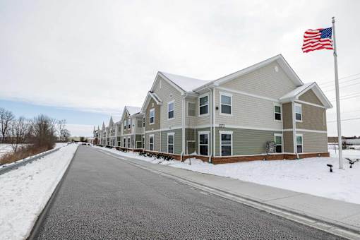 A row of houses with an American flag in front.