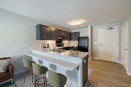 A kitchen with a white countertop and green barstools.