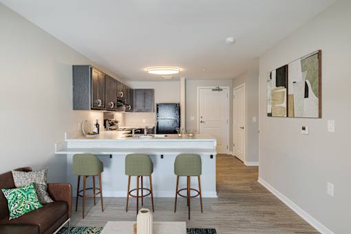 A kitchen with a bar and stools.