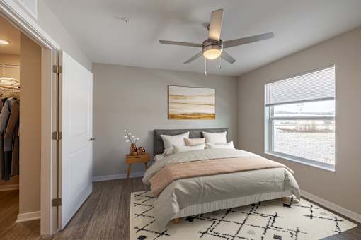 A bedroom with a large bed and a ceiling fan.
