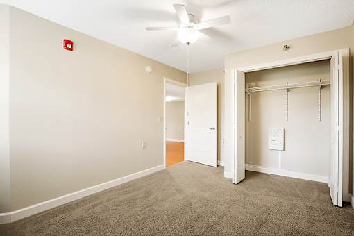 A room with a ceiling fan and a fire alarm.