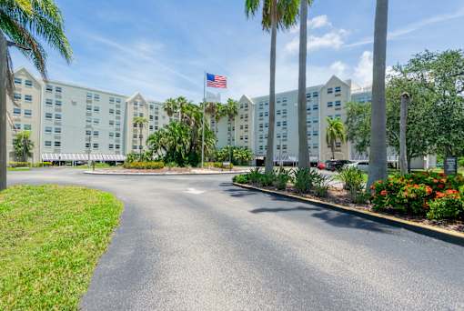 A street view of a hotel with a flag on the building.