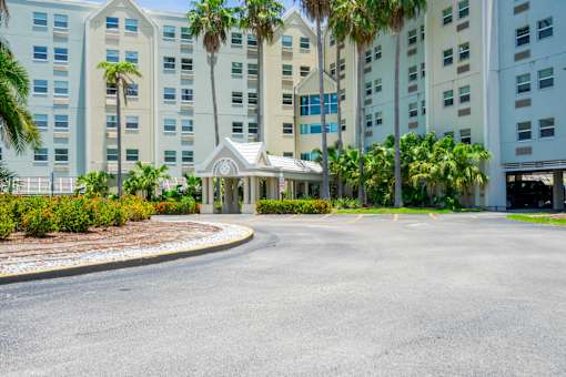 A large white building with a roundabout in front.