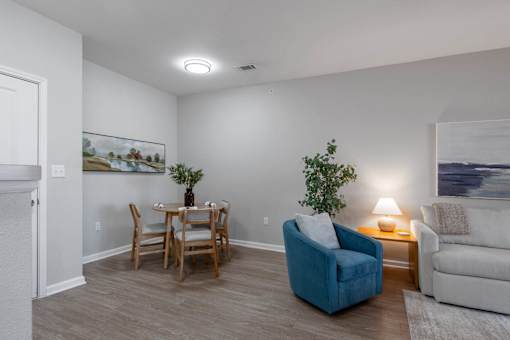 A living room with a blue chair and a painting on the wall at Sunday Village