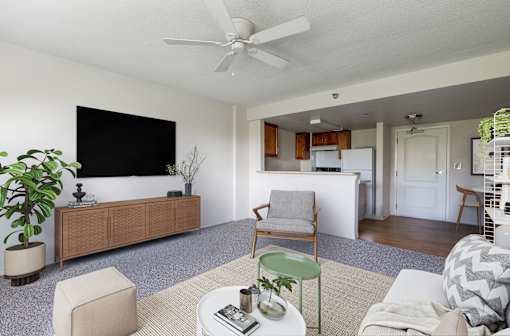 A living room with a white ceiling fan and a flat screen TV mounted on the wall.