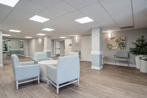 A room with a white ceiling and grey chairs.