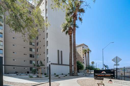 The image shows a modern building with a sign in front that reads "National Church Residences.".