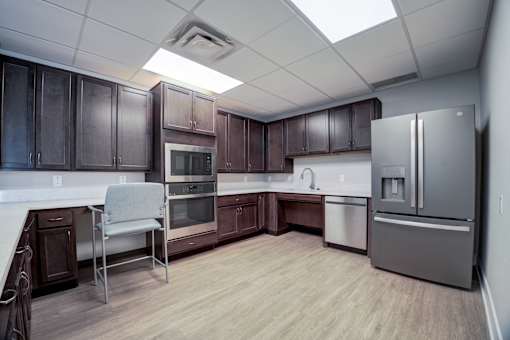A kitchen with brown cabinets and a white counter top.