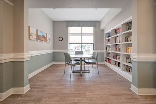 A room with a table and chairs and a bookshelf.